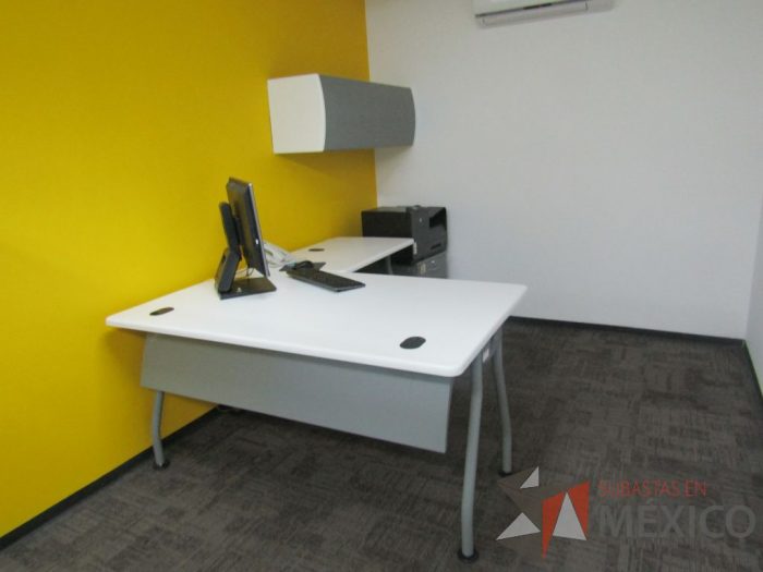 Lote 001 - Escritorio en forma de L con cubierta de color blanco, patas metálicas fijas, con orificios para cables, gaveta con 1 puerta, archivero metálico con 2 cajones y ruedas
