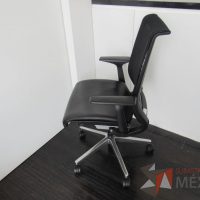 Lote 036 - Silla operativa con ruedas, descansabrazos, asiento tipo piel y respaldo en malla color negro - Imagen 4