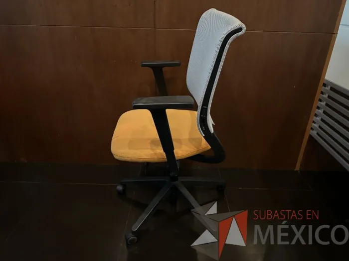 Lote 023 - 2 Sillas operativas con ruedas, descansabrazos, respaldo en malla y asiento en tela color naranja - Imagen 6